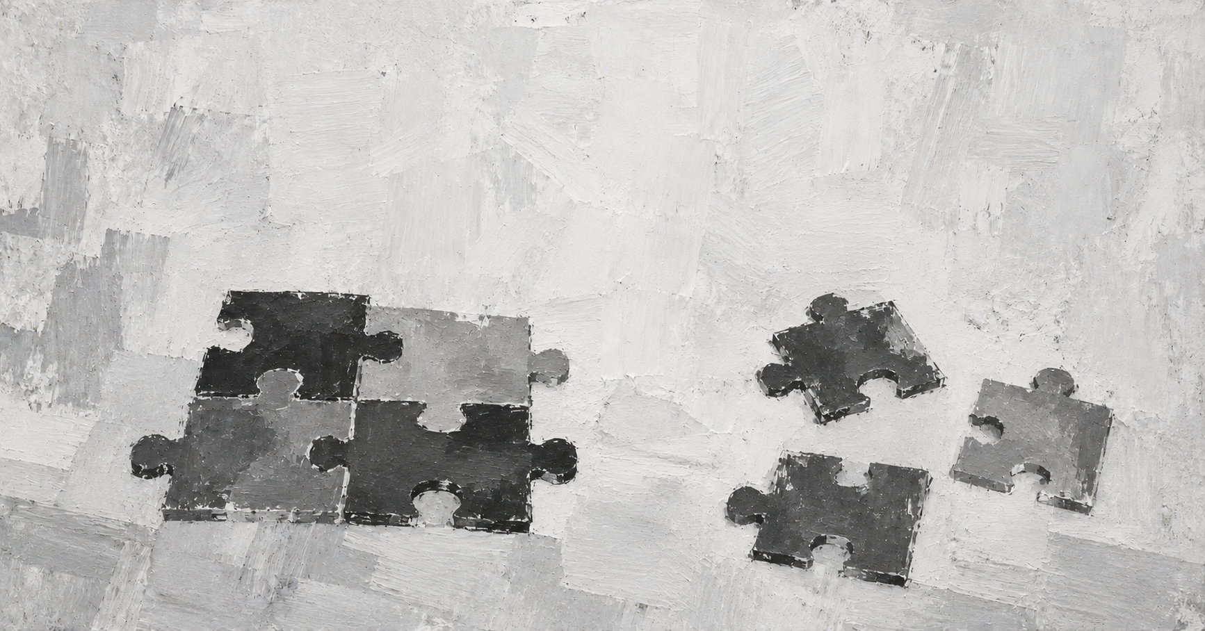 A partially assembled jigsaw puzzle rests beside three loose pieces with open space between them.